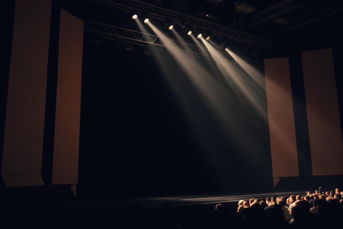 Concert stage with lighting rig and audience silhouettes